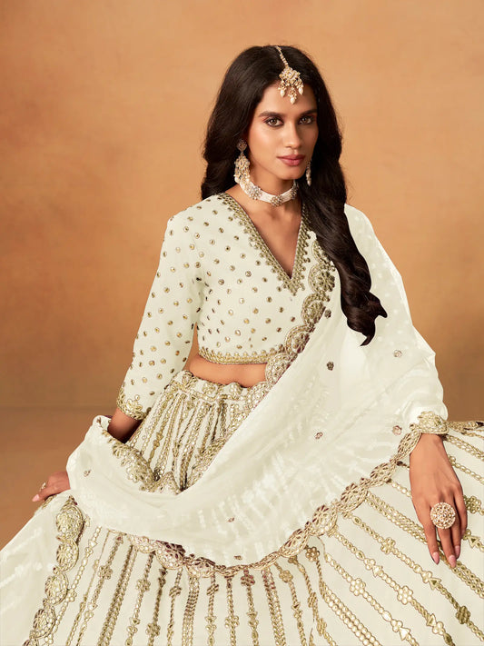Close-up of off white art silk lehenga choli showing paper mirror and embroidery blouse detailing