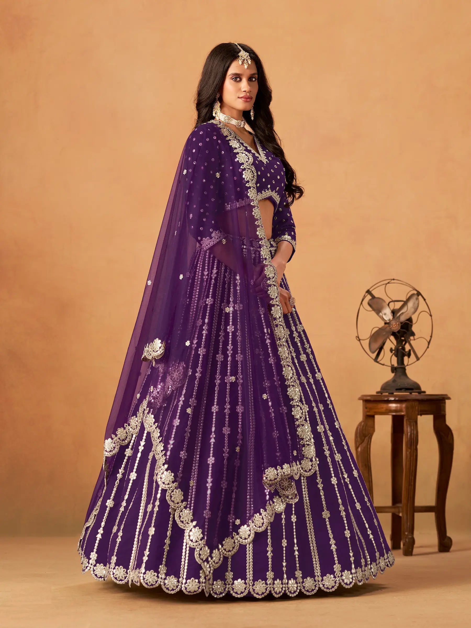 Side view of purple art silk paper mirror and embroidery lehenga choli with dupatta