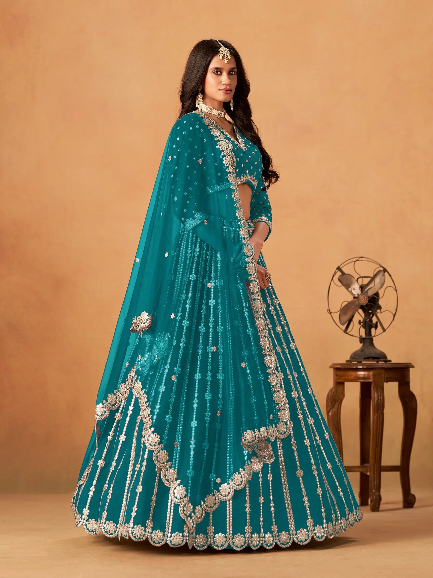 Side view of teal blue art silk paper mirror and embroidery lehenga choli with dupatta