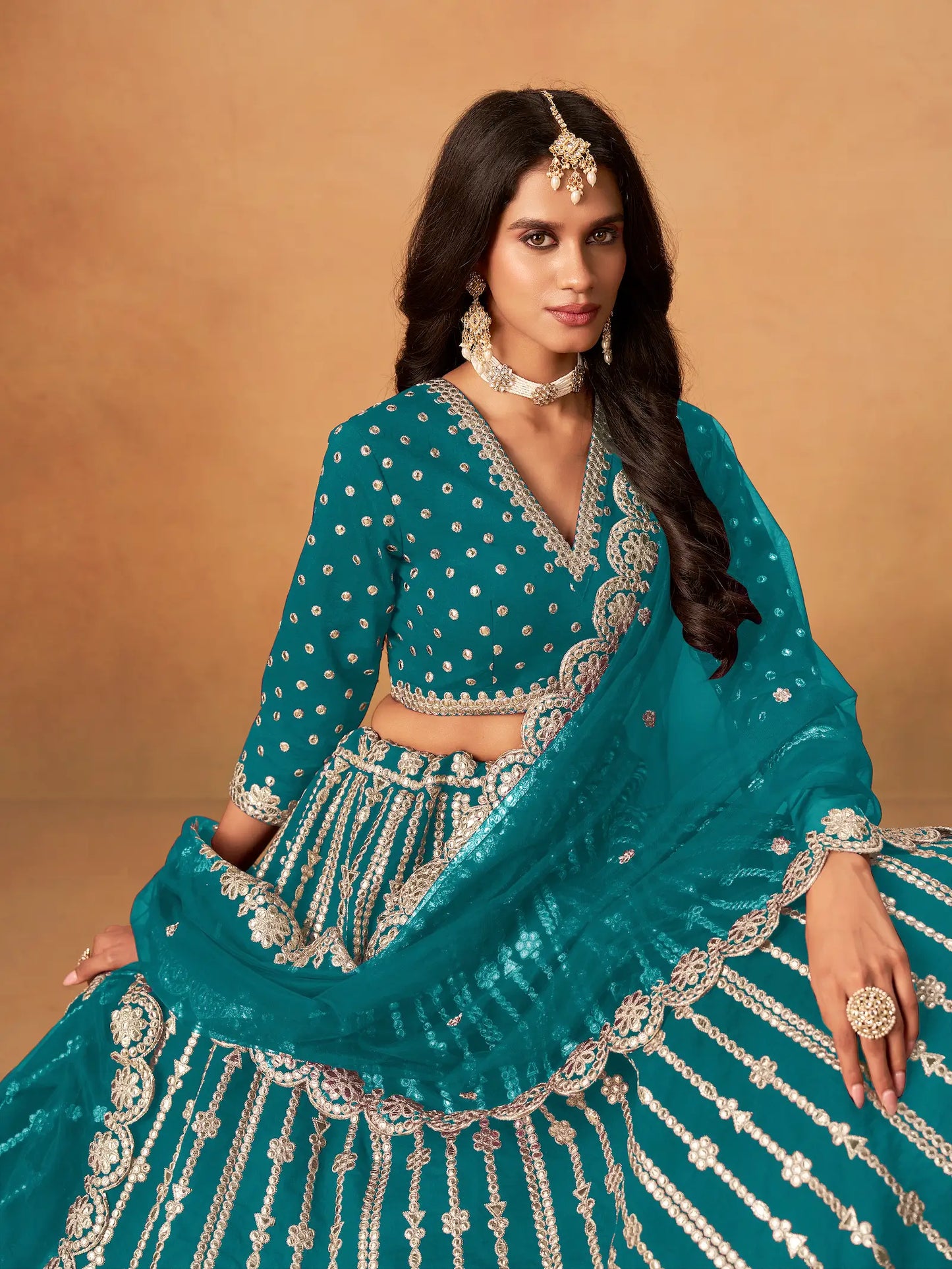 Close-up of teal blue art silk lehenga choli showing paper mirror and embroidery blouse detailing