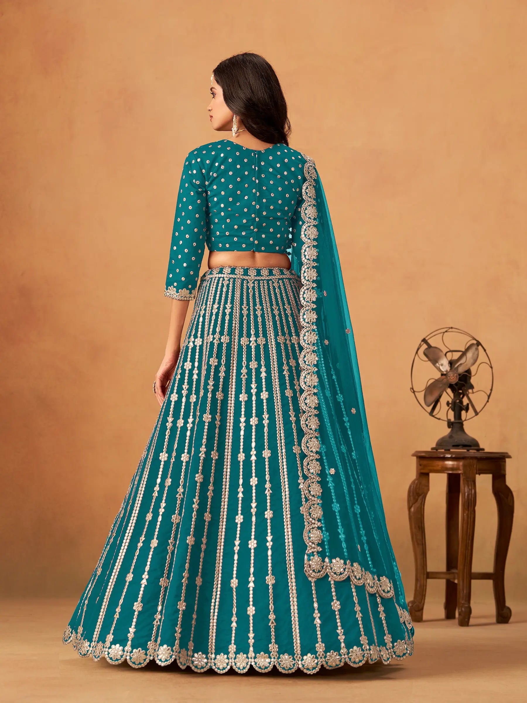 Back view of teal blue art silk paper mirror and embroidery lehenga choli full look