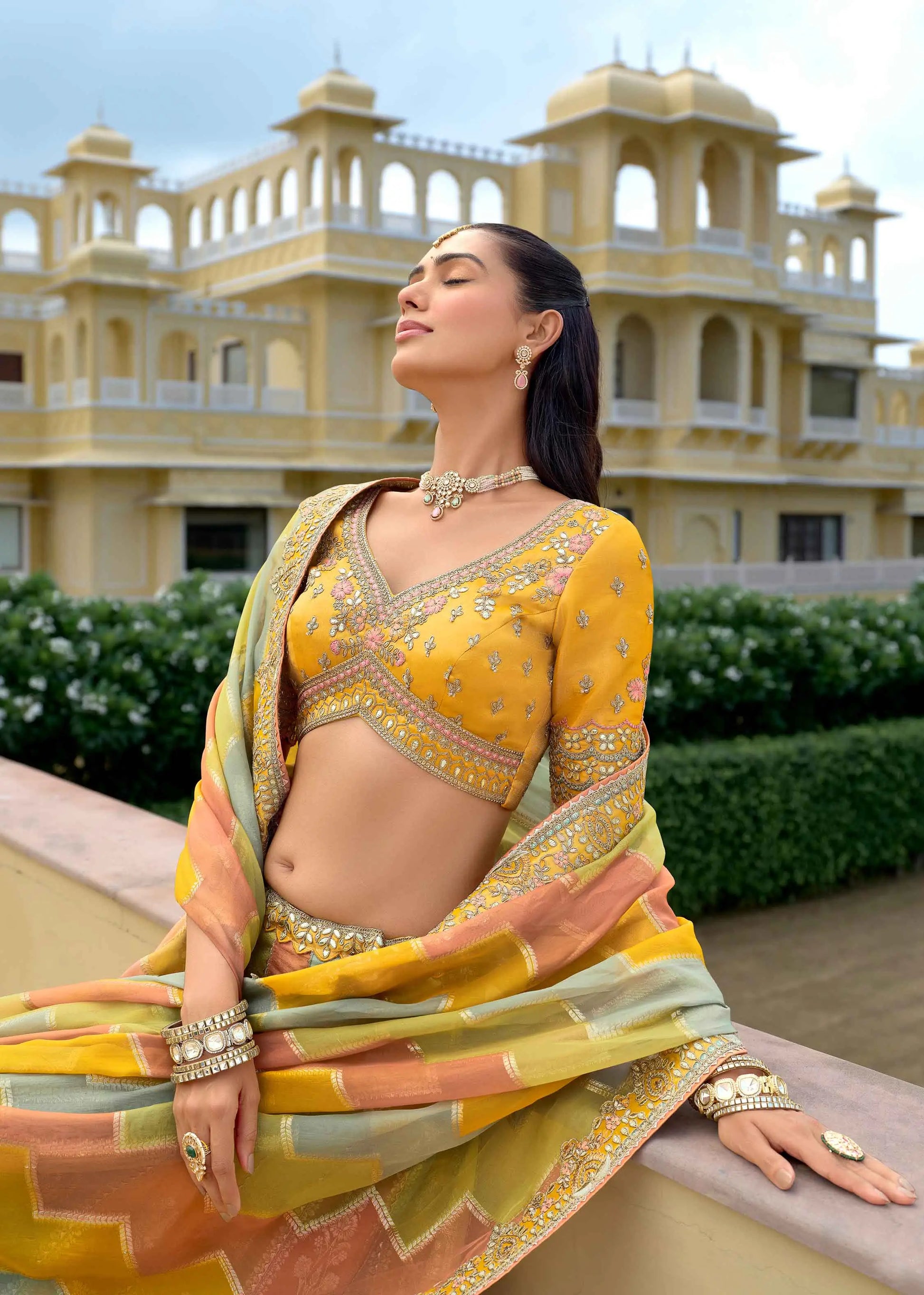 Close-up of pastel yellow lehenga showing detailed designer embroidery work