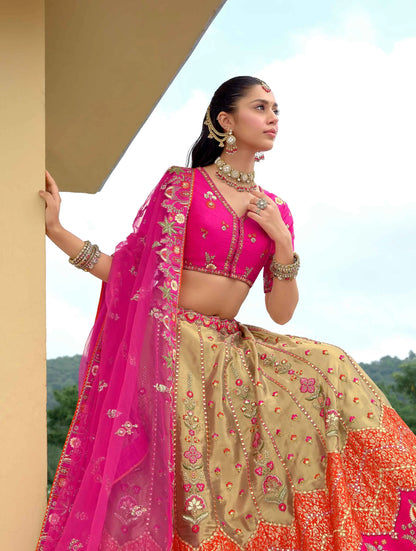 Model sitting wearing designer dark pink lehenga with detailed embroidery work